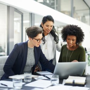 Group of 3 diverse women having a discussion around a computer